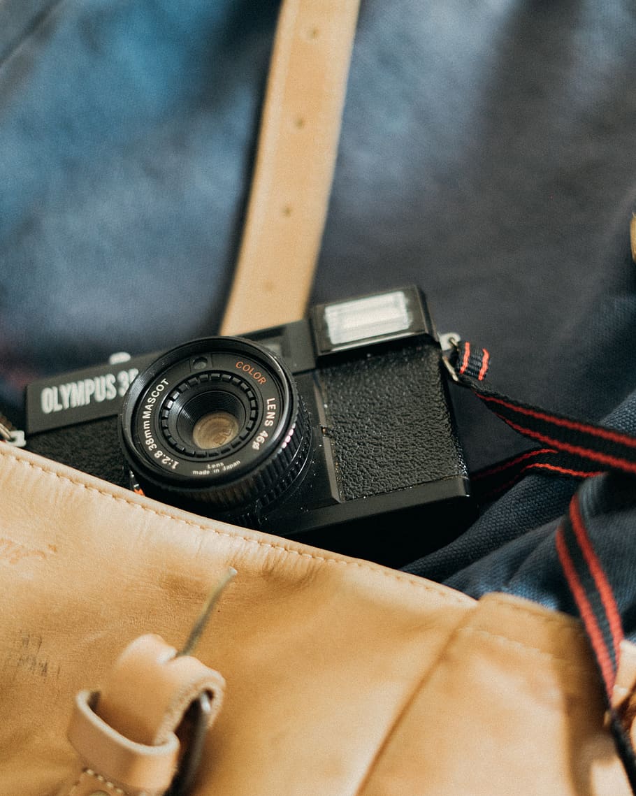 Kamera, Elektronik, Gurt, Armbanduhr, Tasche, Jahrgang, 35mm, Leder, Tapete, Olymp, Vintage Kamera, alt, Digitalkamera, Adapter, Kameraobjektiv, Finger, Holz, Sperrholz, Logo, Warenzeichen, Technologie, drinnen, Nahansicht, Stillleben, Fokus auf den Vordergrund, echte Menschen, Retro-Stil, High Angle View, Fotografie-Themen, Kamera - Fotoausrüstung, Kunst, Kultur und Unterhaltung, Körperteil, Tag, selektiver Fokus, einzelnes Objekt, 2K