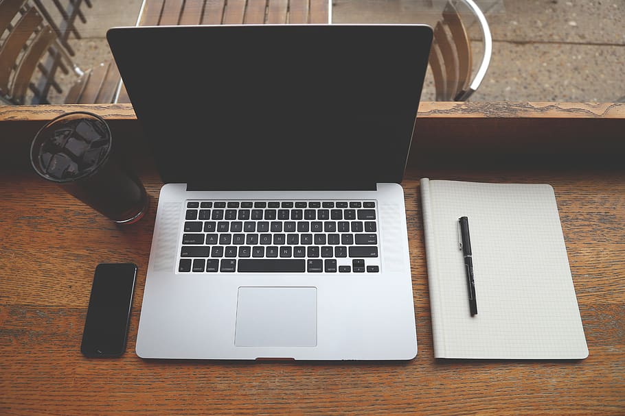 MacBook, portàtil, ordinador, tecnologia, Bloc de notes, bolígraf, iphone, mòbil, beure, negocis, taula, comunicació, connexió, tecnologia sense fils, material de fusta, a l'interior, natura morta, cap gent, dispositiu d’informació portàtil, vista d’angle alt, escriptori, paper, equips informàtics, llibre, mobles, directament a sobre, teclat, 5K