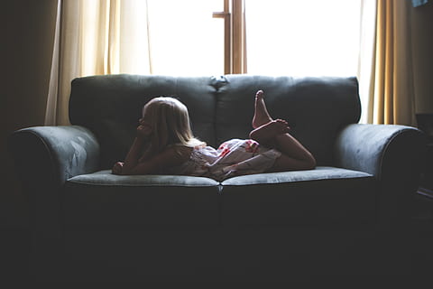 house, interior, couch, sofa, living, room, kid, child, girl, people, relax, window, curtain, furniture, indoors, lifestyles, relaxation, domestic room, one person, sitting, real people, full length, day, women, living room, lying down, leisure activity, home interior, barefoot, adult, body part, feet up, 5K