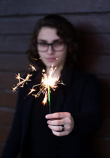 vrouw, staand, bezit, fonkeling, aantrekkelijk, mooi, schoonheid, vervagen, toevallig, detailopname, donker, ogen, brillen, gezichtsuitdrukking, mode, in de mode, focus, haar-, kapsel, hand-, menselijk, dame, lippen, lange blootstelling, op zoek, model-, persoon, fotoshoot, pose, poseren, huid, sterretje, slijtage, jong, jeugd, brandend, verlicht, een persoon, beweging, gloeiend, vooraanzicht, vonken, wazig beweging, brand, evenement, viering, vuur - natuurverschijnsel, nacht, jonge volwassene, kunst cultuur en entertainment, volwassen, vuurwerk, vuurwerk - door de mens gemaakt object, tiener, 4K, CC0, publiek domein, royaltyvrij