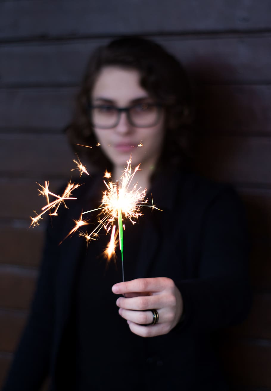 dona, de peu, celebració, espurna, atractiu, bonic, bellesa, borrós, casual, primer pla, fosc, ulls, ulleres, expressió facial, moda, de moda, femella, focus, cabell, pentinat, mà, humà, senyora, llavis, exposició llarga, mirant, model, persona, sessió de fotos, pose, posant, pell, sparkler, desgast, jove, joventut, cremant, il·luminat, una persona, moviment, brillant, vista frontal, espurnes, moviment borrós, foc, esdeveniment, foc - fenomen natural, nit, adult jove, cultura i entreteniment artístic, adult, focs artificials, focs artificials - objecte fet per l'home, adolescent, 4K
