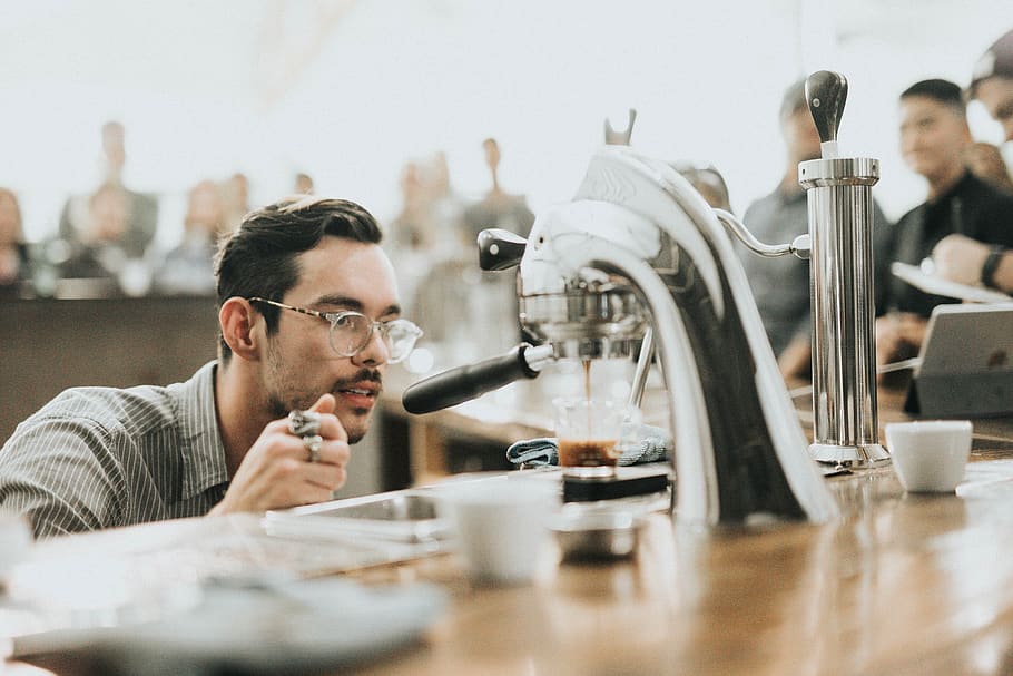 cafè, fabricant, màquina, calenta, beure, elaborada, espresso, taula, gent, home, paio, barista, cafeteria, botiga, negocis, adult, tirada al cap, homes, una persona, a l'interior, treball, mig adult, assegut, retrat, persones reals, gots, homes de mitjana edat, home jove, menjar i beguda, concentració, enfocament selectiu, 2K