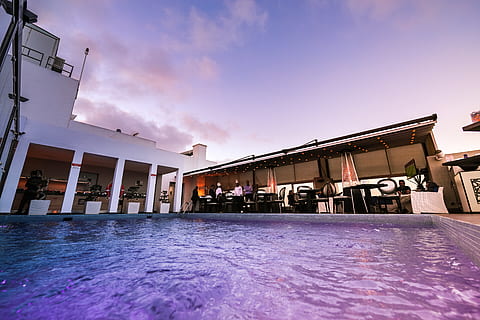 swimming pool, architecture, building, hotel, pool, resort, sky, built structure, building exterior, nature, cloud - sky, sunset, water, incidental people, outdoors, day, city, cold temperature, waterfront, blue, purple, 5K, CC0, public domain, royalty free