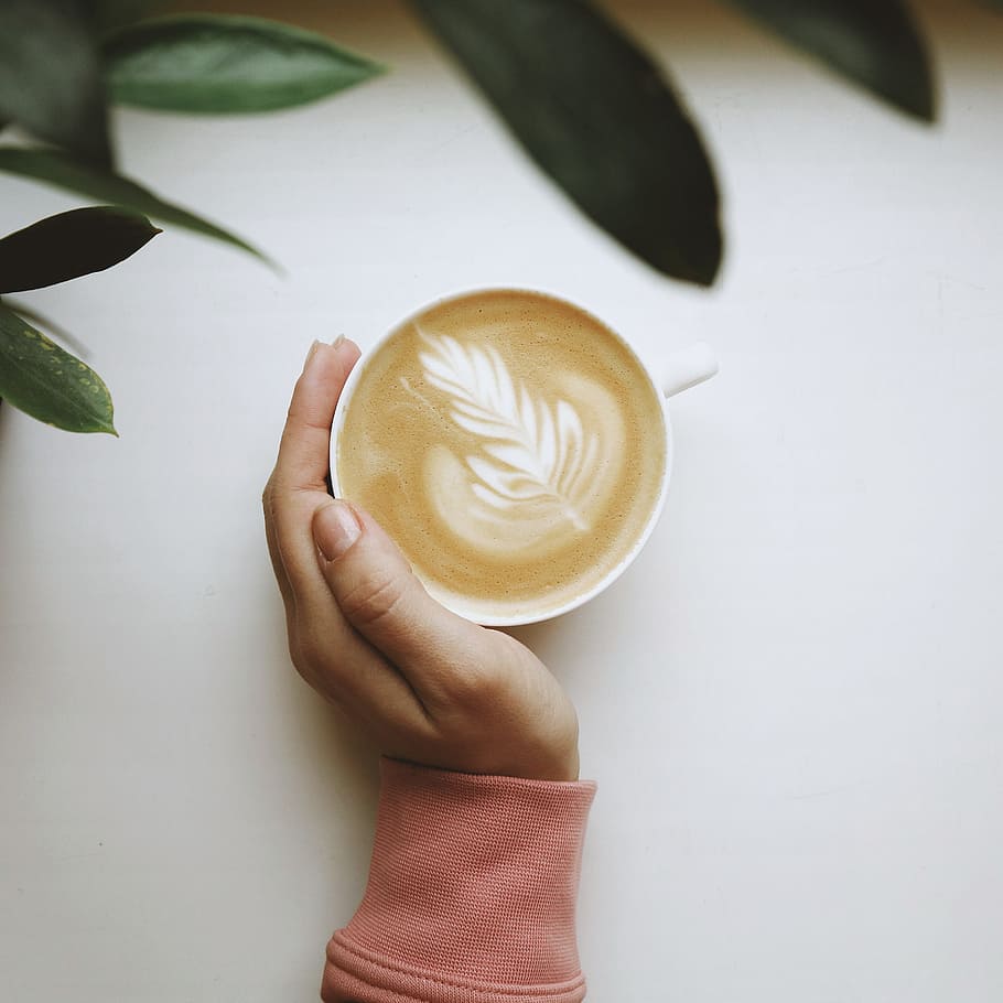 hvid keramisk kop, kaffe, flatlay, kaffe flatlay, hånd, humør, latte, mælk, velsmagende, sjovt, grøn, grønne, grønt blad, varm drikke, drikke, kaffe pause, kaffekrus, kop, cappuccino, bord, varme - temperatur, cafe, koffein, kaffe - drikke, espresso, træ - materiale, Brun, baggrunde, morgenmad, mad, friskhed, tæt på, gourmet, mokka, latte kunst, hvid, morgen, skummende drikke, kaffekop, forfriskning, menneskelig hånd, 2K