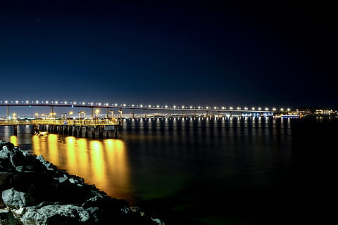 encès, pont, nit, aigua, davant del mar, port, moll, edifici, passeig marítim, il·luminació, barana, a l'aire lliure, línia de costa, habitatge, casa, esquena, naturalesa, Parc d'atraccions, reflexió, il·luminat, cel, arquitectura, estructura construïda, cap gent, cel clar, escenics - natura, riu, còpia espai, exterior de l'edifici, connexió, estrella - espai, 2K, CC0, domini públic, lliure de regalies