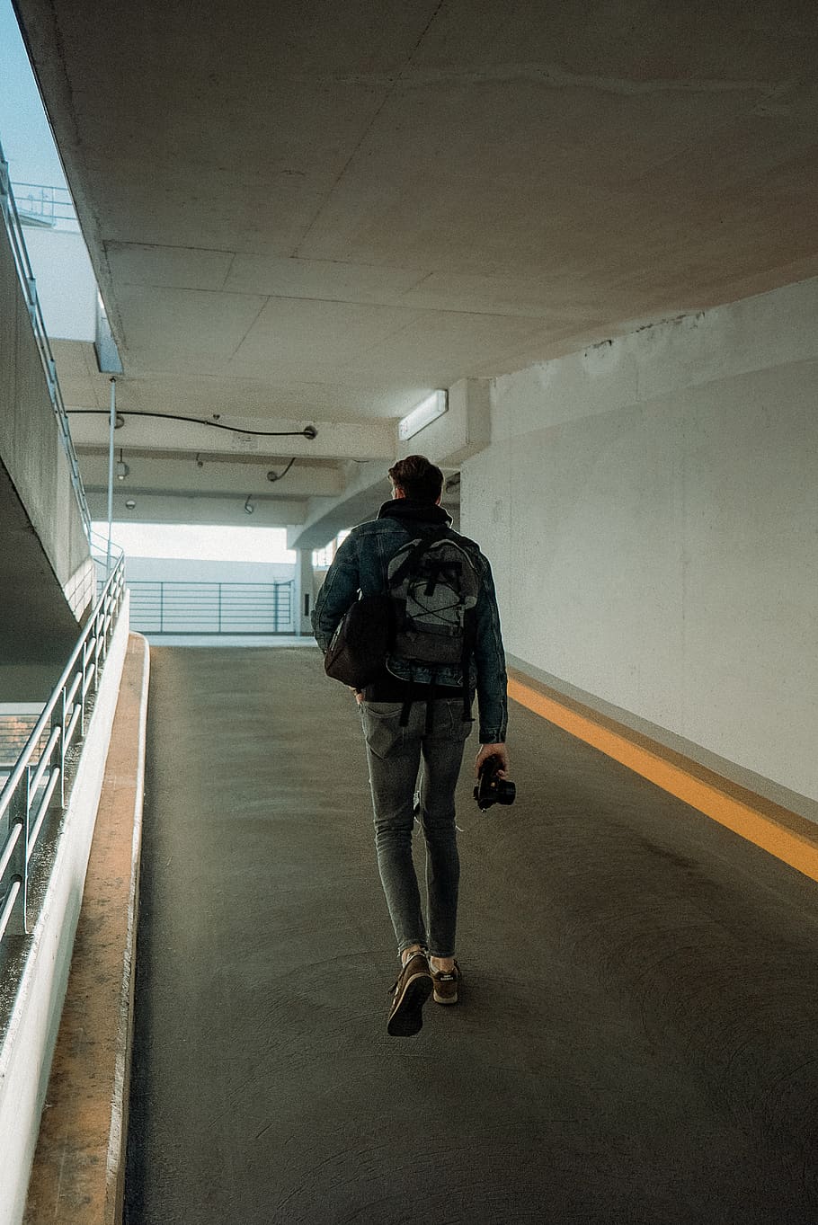 Mann, Gehen, Weg, Person, Mensch, Geländer, bekleidung, Kleidung, Hose, Deutschland, Köln, Mantel, Jacke, Bodenbelag, Schuh, Schuhwerk, Denim, Jeans, Gang, Fußgänger, Fußboden, die Architektur, in voller Länge, eine Person, echte Menschen, Rückansicht, gebaute Struktur, drinnen, Lebensstile, Bewegung, Rucksack, Männer, Gebäude, Transport, Freizeitbeschäftigung, Legere Kleidung, Tasche, unterwegs, Decke, 5K