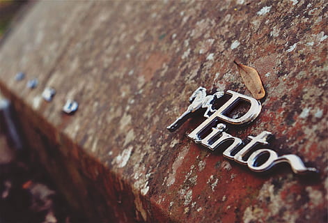 pinto, car, vintage, old, rust, classic, emblem, no people, text, close-up, selective focus, metal, wall - building feature, communication, textured, rusty, weathered, day, solid, wall, western script, wood - material, rock, rock - object, outdoors, low angle view, 1080P, CC0, public domain, royalty free