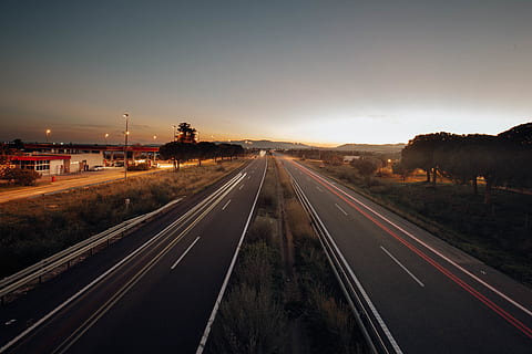 to asfaltveje, asfalt, mørk, aften, motortrafikvej, gyldne horisont, gylden time, hovedvej, lys, lang eksponering, vej, solnedgang, tidsforskydning, træer, transportmidler, himmel, vejen frem, retning, natur, skilt, ingen mennesker, mærkning, vejmærkning, transportform, gade, belyst, faldende perspektiv, symbol, forsvindingspunkt, bil, motor køretøj, udendørs, multiple lane motorvej, skillelinje, 4K, CC0, offentligt domæne, royaltyfrie