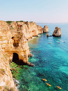 rock cliff, ocean, kayakers, speed boat, passing, beach, cave, cliffs, daylight, grass, landscape, nature, rock formation, rocks, sand, scenic, sea, seascape, seashore, shore, sky, water, watercrafts, waves, rock, rock - object, solid, scenics - nature, beauty in nature, tranquility, tranquil scene, land, non-urban scene, clear sky, idyllic, day, no people, arch, natural arch, horizon over water, outdoors, eroded, rocky coastline, turquoise colored, formation, stack rock, 4K, CC0, public domain, royalty free