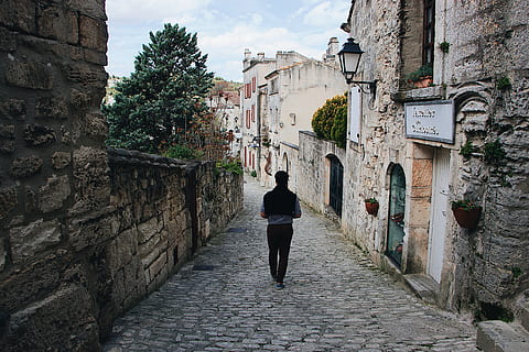 passarel·la, Camí, vorera, paviment, persona, humà, llosa, llambordes, paret, baux-de-provence, França, esquena, arbre, finestra, sabata, furgonetes, motxilla, ciutat, provence, homes, arquitectura, estructura construïda, exterior de l'edifici, vista del darrere, edifici, una persona, persones reals, longitud completa, direcció, el camí a seguir, estils de vida, sendera, caminar, dia, activitat d'oci, carreró, dones, a l'aire lliure, paret de pedra, 5K, CC0, domini públic, lliure de regalies