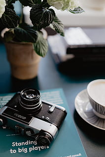 old, analog camera, photography book, book, reading, camera, photography, photographer, learning, analog, table, no people, close-up, focus on foreground, indoors, technology, selective focus, camera - photographic equipment, photography themes, still life, plant, arts culture and entertainment, potted plant, photographic equipment, retro styled, leaf, plant part, black color, day, digital camera, 4K, CC0, public domain, royalty free
