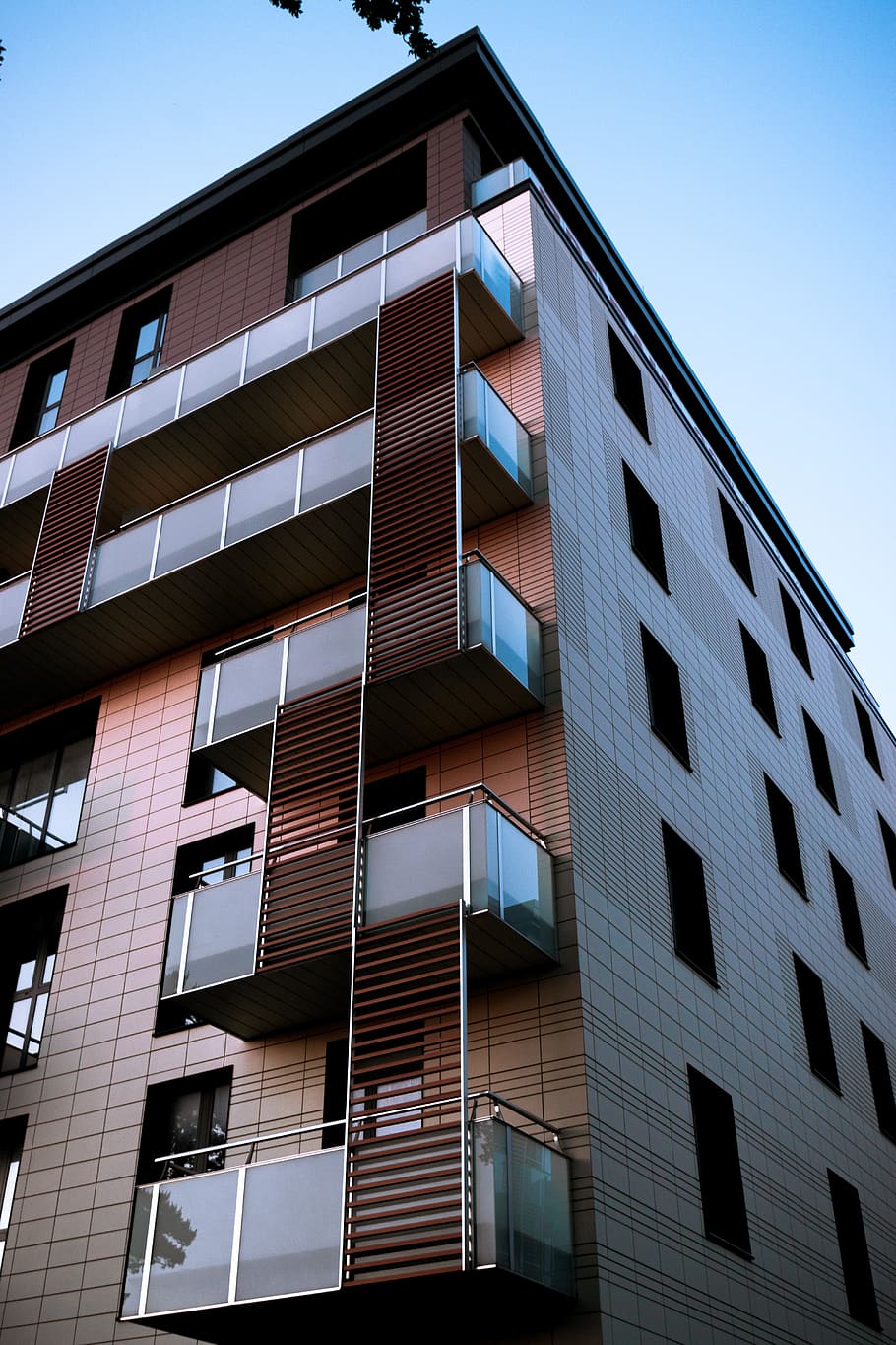 edifici pintat de color marró, barana, edifici, edifici d'oficines, decoració de la llar, condomini, habitatge, casa, edifici d'apartaments, de gran alçada, ciutat, urbà, finestres, factura, posta de sol, sol, blau, finestra, escala, estructura construïda, arquitectura, exterior de l'edifici, vista d’angle baix, cel, cap gent, vidre - material, cel clar, oficina, dia, naturalesa, a l'aire lliure, modern, reflexió, exterior d’edifici d’oficines, en fila, llum solar, apartament, 5K