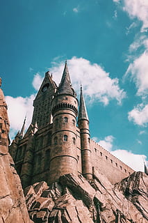 brown castle , architecture, building, castle, gothic, tourism, universal studios, built structure, sky, building exterior, cloud - sky, low angle view, the past, history, day, nature, travel destinations, no people, tower, place of worship, religion, ancient, outdoors, travel, spirituality, ancient civilization, spire, 2K, CC0, public domain, royalty free