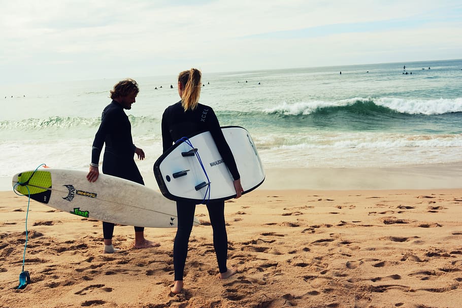 home, dona, celebració, taules de surf, vora del mar, acció, platja, diversió, paisatge, oci, oceà, gent, recreació, relaxació, sorra, mar, paisatge marí, estiu, navega, surfboarding, surfistes, vacances, aigua, onades, terra, activitat d'oci, estils de vida, persones reals, longitud completa, horitzó sobre l’aigua, horitzó, bellesa a la natura, cel, de peu, onada, dones, naturalesa, unió, 5K