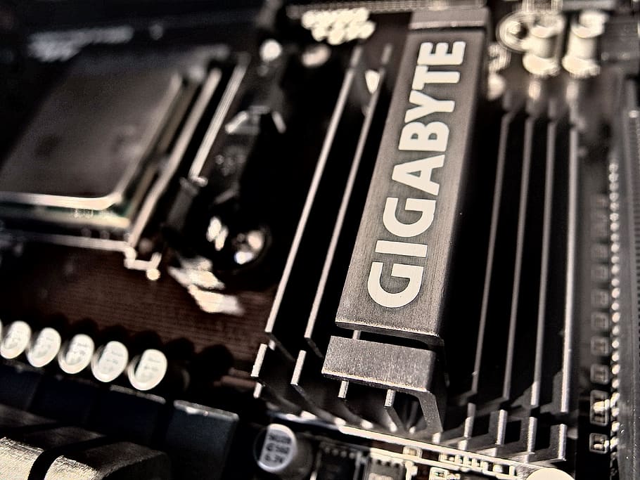 placa base negra de gigabytes, condensadors, CPU, dispositiu, electrònica, gigabyte, dissipador de calor, metall, placa base, processador, acer, tecnologia, comunicació, primer pla, cap gent, nombre, a l'interior, text, connexió, enfocament selectiu, màquina d’escriure, part de l’ordinador, equipament, fons, maquinària, ordinador, marc complet, estil retro, equips informàtics, indústria electrònica, 4K