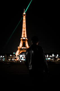 Torre Eiffel, París, persona, humà, arquitectura, edifici, torre, campanar, fletxa, ciutat, metròpolis, urbà, roba, centre de la ciutat, vida nocturna, abric, vianants, il·luminació, jaqueta, monument, nit, il·luminat, vista del darrere, destinacions de viatge, estructura construïda, vida de ciutat, viatjar, turisme, exterior de l'edifici, carrer, una persona, homes, cel, còpia espai, 5K, CC0, domini públic, lliure de regalies
