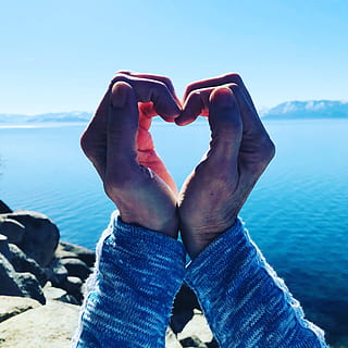 person, folded, hands, body, water, daytime, heart, man, ocean, outdoors, rocks, sea, seascape, seashore, shape, one person, nature, human body part, body part, lifestyles, human hand, sky, day, real people, hand, leisure activity, blue, personal perspective, beauty in nature, heart shape, sunlight, finger, 2K, CC0, public domain, royalty free