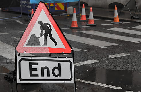 end sign, road sign, symbol, person, human, sign, road, tarmac, asphalt, triangle, road cones, london, street, raining, signage, end, path, cone, city, urban, metropolis, communication, guidance, safety, human representation, representation, day, transportation, no people, information sign, text, road marking, focus on foreground, information, male likeness, outdoors, 5K, CC0, public domain, royalty free