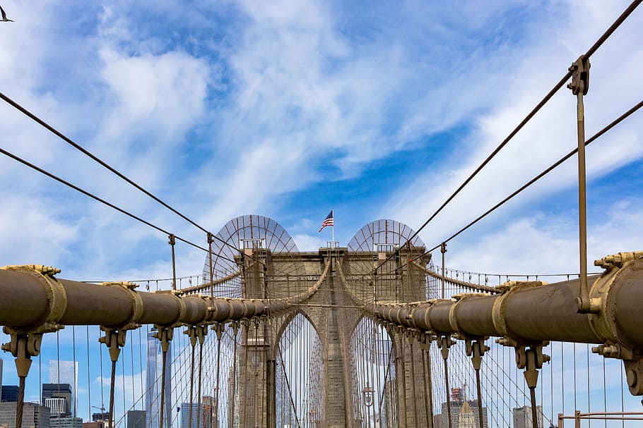 pont de Brooklyn, nou, York, arquitectura, pont, edifici, núvols, equipament, bandera, referència, tir en angle baix, new york, nova York, a l'aire lliure, cel, acer, Pont en suspensió, viatjar, núvol - cel, estructura construïda, naturalesa, connexió, vista d’angle baix, dia, transport, cap gent, ciutat, exterior de l'edifici, destinacions de viatge, blau, indústria, negocis, cable, 5K