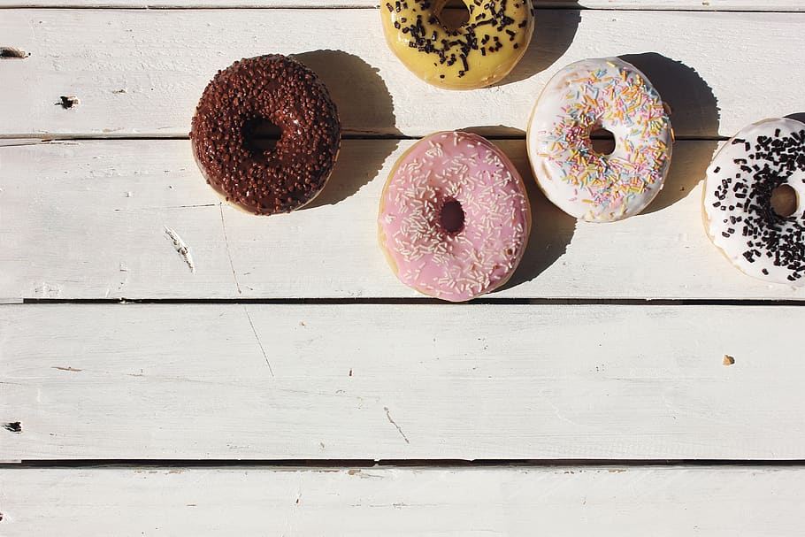 fie donuts, menjar i beguda, material de fusta, menjar, directament a sobre, taula, frescor, donut, menjar dolç, a l'interior, dolç, al forn, cap gent, llest per menjar, indulgència, natura morta, postres, vista d’angle alt, fruita, alimentació saludable, variació, temptació, 5K