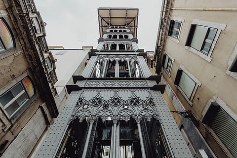 view, historic, elevator, lisbon, portugal, lift, santa justa lift, built structure, architecture, building exterior, low angle view, building, no people, window, day, old, residential district, history, the past, staircase, railing, directly below, travel destinations, sky, outdoors, city, religion, ceiling, ornate, ruined, 5K, CC0, public domain, royalty free
