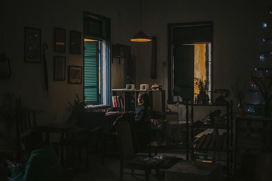 kvinne som bruker skrivebordet, arkitektur, stol, mørk, rammer, møbler, innendørs, interiørdesign, lampe, lys, person, rom, sete, belyst, belysningsutstyr, bord, ekte folk, én person, virksomhet, bygget struktur, teknologi, hjemlige rom, menn, hjem interiør, datamaskin, livsstil, elektrisk lampe, 4K