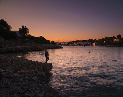 woman, standing, body, water, night, beach, clouds, dawn, evening, horizon, landscape, light, ocean, person, reflection, rocks, sea, seashore, sky, sunset, town, tree, beauty in nature, scenics - nature, nature, silhouette, solid, rock, real people, rock - object, tranquil scene, land, tranquility, one person, outdoors, 4K, CC0, public domain, royalty free