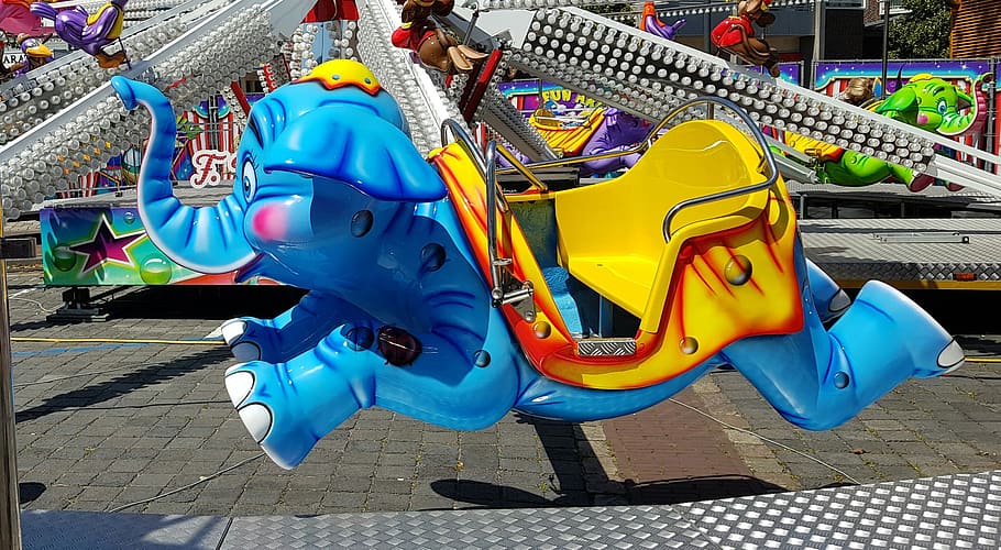carrusel, kiddie ride, diversió, colorit, elefant, atracció, dia, blau, cultura i entreteniment artístic, parc infantil, infància, Parc d'atraccions, groc, llum solar, a l'aire lliure, persones reals, vista d’angle alt, representació animal, naturalesa, passeig pel parc d’atraccions, equip de joc a l'aire lliure, multicolor, arquitectura, representació, longitud completa, ombra, inflable, 2K