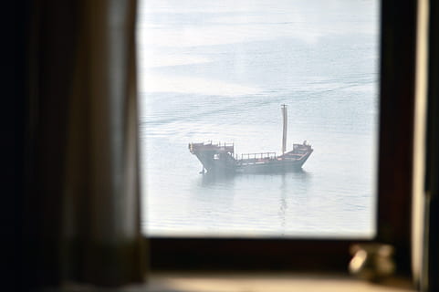 brown ship, transportation, boat, vehicle, ship, tanker, freighter, watercraft, vessel, screen, electronics, military, cruiser, navy, cargo, steamer, indoors, interior design, shipping container, monitor, display, window, day, water, glass - material, selective focus, nautical vessel, no people, transparent, reflection, nature, focus on background, sea, table, sky, mode of transportation, container, 5K, CC0, public domain, royalty free