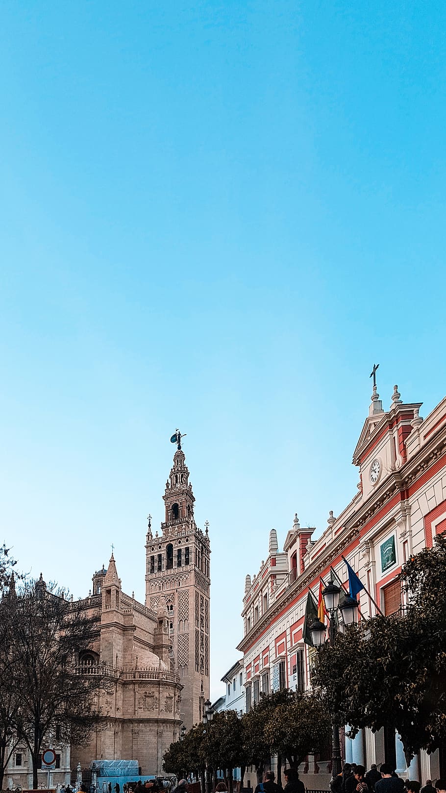 edifici, arquitectura, torre, campanar, fletxa, ciutat, centre de la ciutat, urbà, persona, humà, espana, sevilla, metròpolis, la giralda, carrer, vianants, giralda, exterior de l'edifici, estructura construïda, cel, cel clar, blau, naturalesa, còpia espai, vista d’angle baix, religió, dia, arbre, espiritualitat, creença, cap gent, el passat, lloc de culte, destinacions de viatge, a l'aire lliure, 4K