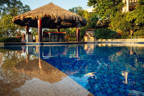 brown, hut, swimming, pool, architecture, hotel, poolside, resort, swimming pool, water, built structure, reflection, building exterior, tree, nature, no people, lake, plant, day, building, waterfront, gazebo, travel destinations, tourist resort, outdoors, luxury, 1080P, CC0, public domain, royalty free
