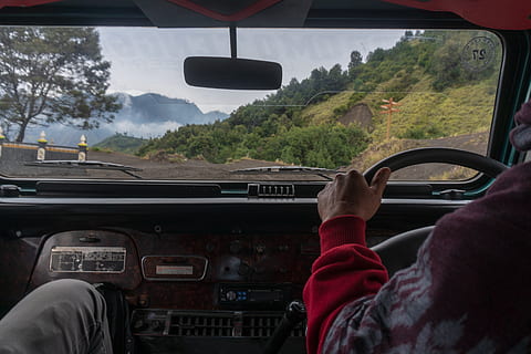 person driving, adventure, bromo, dashboard, daylight, dirt road, drive, driver, offroad, road, steering wheel, transportation system, vehicle, windshield, mode of transportation, transportation, vehicle interior, car, land vehicle, transparent, glass - material, one person, men, motor vehicle, driving, human hand, real people, rear view, tree, car interior, travel, human body part, hand, rear-view mirror, 5K, CC0, public domain, royalty free