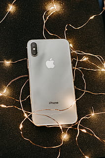argent iphone x, mensonge, guirlandes lumineuses, dispositif de communication, dispositif, iphone, iphone x, mobile, téléphone, portable, téléphone intelligent, La technologie, à l'intérieur, illuminé, la communication, lien, personne, lumière électrique, câble, nature morte, fermer, émotion, vue grand angle, Technologie sans fil, embrasé, lumière, fête, émotion positive, forme de coeur, Noël, chaîne, 5K, CC0, domaine public, libre de droits