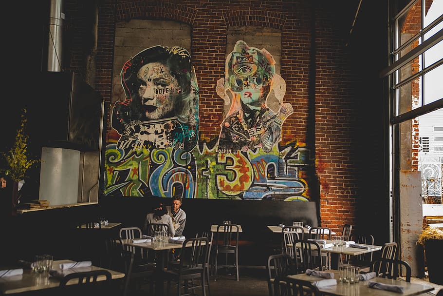 indre, rustik, cafe, stol, møbel, restaurant, human, person, cafeteria, kunst, mad, mad domstol, bord, vægmaleri, maleri, spisebord, pub, graffiti, terrasse, måltid, væg, krypt, menneskelig repræsentation, repræsentation, kreativitet, Kunst og håndværk, arkitektur, bygget struktur, sæde, mandlig lighed, indendørs, ingen mennesker, bygning, kvindelig lighed, skulptur, statue, forretning, tro, glas, 8K