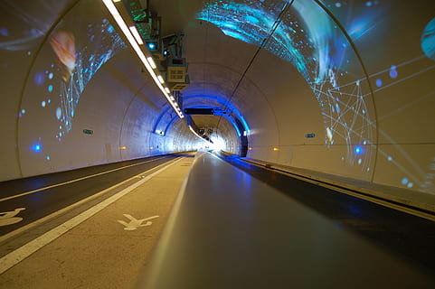 cloud, grass, racing, path, shiny, outside, direction, move, sign, glass, reflection, trip, perspective, scenic, empty, technology, race, driving, futuristic, velocity, illuminated, the way forward, transportation, tunnel, road, lighting equipment, architecture, diminishing perspective, arch, indoors, road marking, built structure, no people, motion, night, vanishing point, marking, light, ceiling, long, light at the end of the tunnel, 2K, CC0, public domain, royalty free