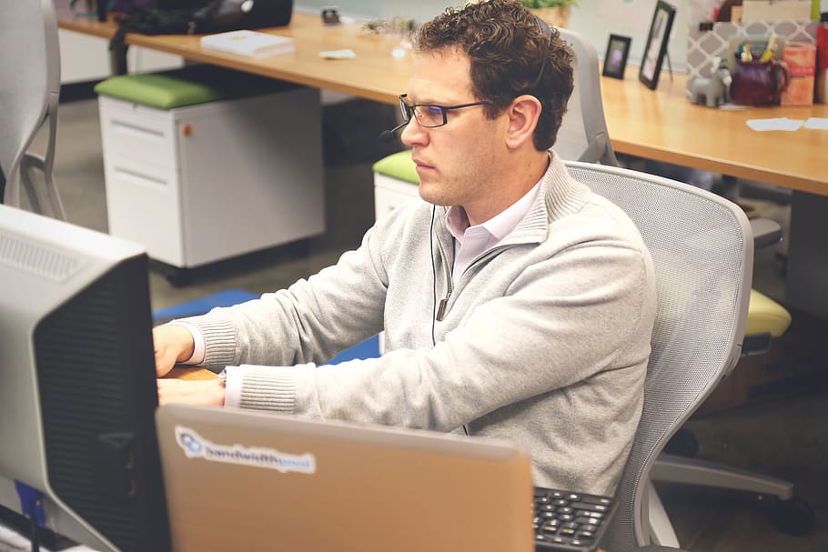 home, assegut, gris, cadira, adult, codificador, codificació, empresa, concentració, coworking, cubicle, escriptori, empleat, feina, oficina, persona, programador, programació, tecnologia, espai de treball, lloc de treball, ordinador, persones reals, una persona, treball, connexió, cintura cap amunt, comunicació, negocis, portàtil, adult jove, tecnologia sense fils, ocupació, ocupació professional, persona de negocis, a l'interior, usant portàtil, 5K