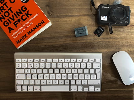 espai de treball creatiu, espai de treball, càmera, mac, llibre, treballar, fotografia, taula, tecnologia, ordinador, equips informàtics, a l'interior, material de fusta, teclat, directament a sobre, teclat d’ordinador, comunicació, text, cap gent, vista d’angle alt, guió occidental, natura morta, tecnologia sense fils, connexió, mobles, escriptori, portàtil, polsador, 1080P, CC0, domini públic, lliure de regalies