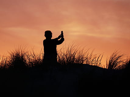 silhuet fotografi, person, stående, græsser, baggrundsbelyst, skyer, daggry, aften, aftenhimmel, græs, landskab, lys, natur, fotografi, billedoptagelse, romantisk, skygge, solnedgang, silhuet, himmel, en person, menneskelige arm, fritidsaktivitet, sky - himmel, plante, livsstil, arme hævet, tre kvart længde, rigtige mennesker, orange farve, skønhed i naturen, jord, Mark, ro, udendørs, frihed, 4K, CC0, offentligt domæne, royaltyfrie