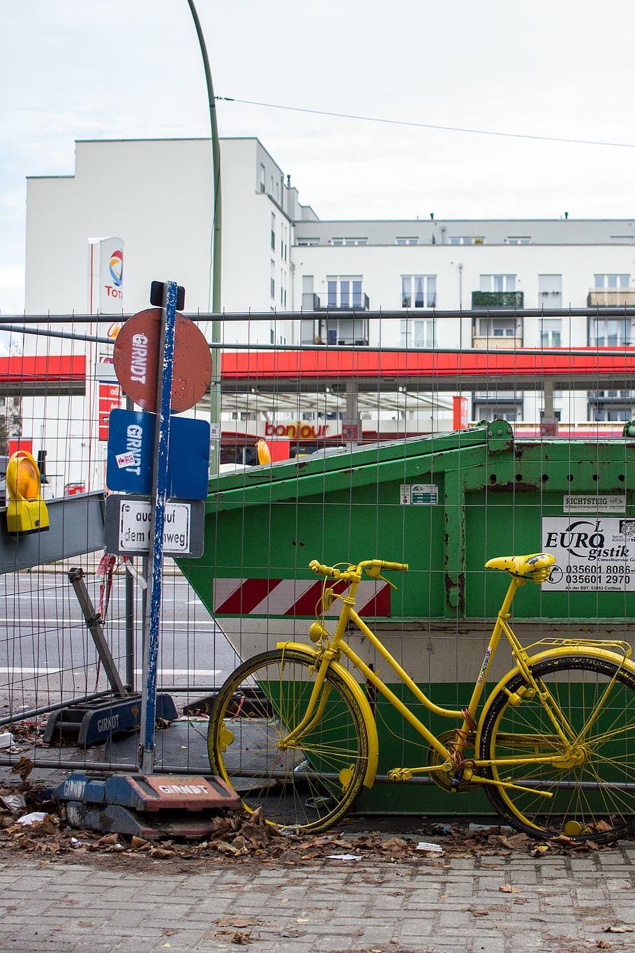 Alemanya, Berlín, costat de la construcció, urbà, bicicleta, groc, verd, caure, lot d’edificis, contenidor, obres de carretera, brutícia, escombraries, estació de servei, hivern, baustelle, transport, manera de transport, vehicle terrestre, dia, cap gent, arquitectura, estructura construïda, exterior de l'edifici, transport públic, ciutat, transport per ferrocarril, a l'aire lliure, viatjar, text, estacionari, naturalesa, barana, barrera, comunicació, roda, 2K