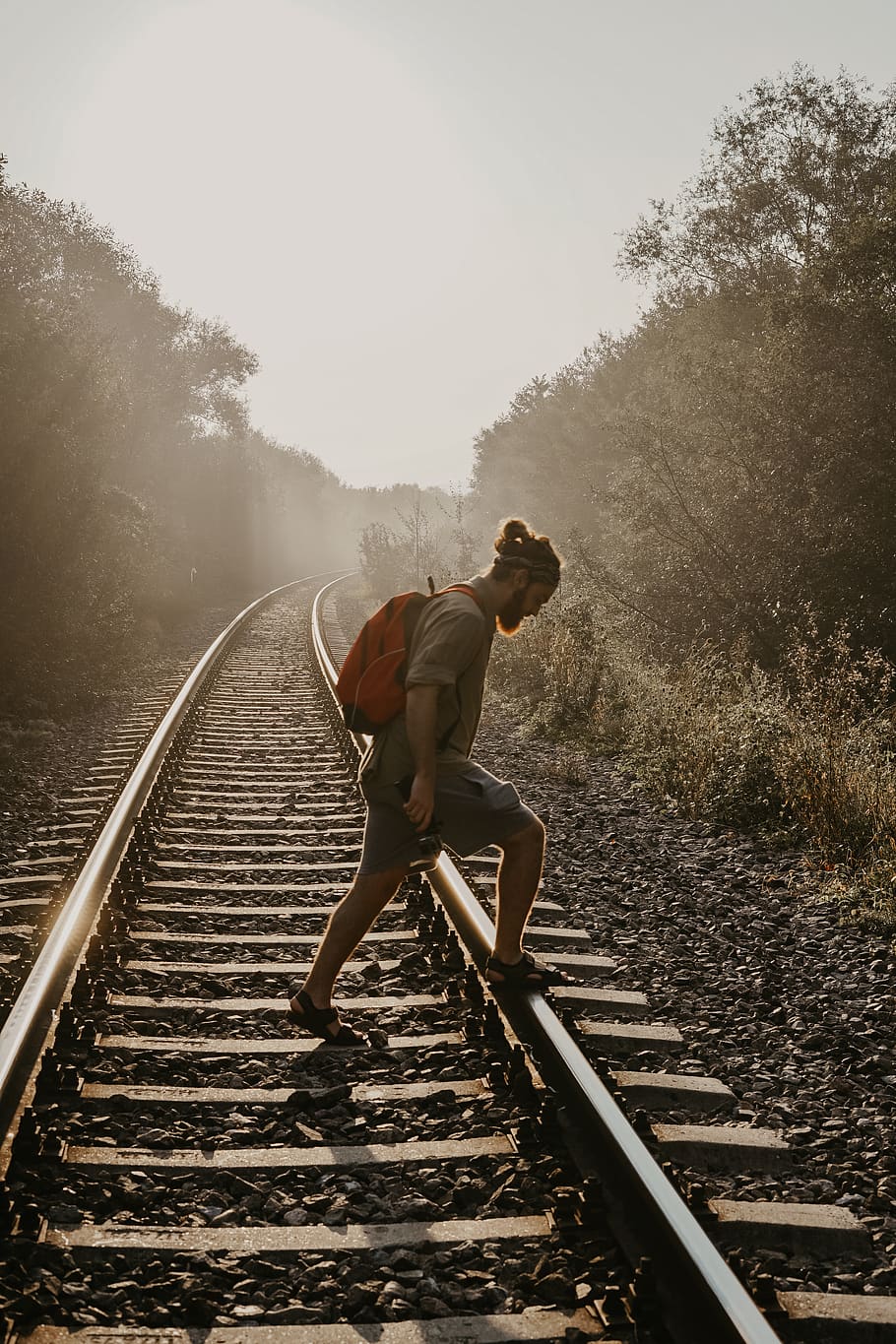 home que passa per sobre del tren, transport, pista de tren, ferrocarril, rail, humà, persona, escala, carretera, Carretera bruta, grava, samarreta, roba, electrònica, pantalla, monitor, runes, esports, pista d'atletisme, una persona, longitud completa, persones reals, transport per ferrocarril, arbre, estils de vida, vies del ferrocarril, pista, planta, naturalesa, roba casual, dia, adult jove, activitat d'oci, homes, adult, el camí a seguir, vista lateral, a l'aire lliure, curts, esforç, 4K