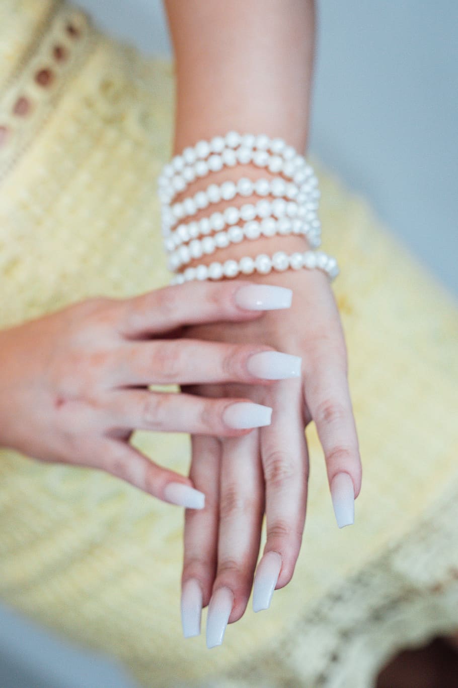 braccialetto bianco con perline, parte del corpo umano, mano umana, mano, avvicinamento, adulto, donne, parte del corpo, in casa, concentrarsi sulle conoscenze acquisite, Sezione centrale, bambino, detenzione, giorno, chiodo, femmine, mani giunte, lusso, dito, manicure, piede umano, 5K