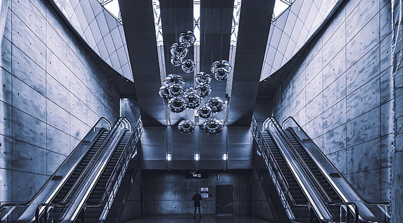 persona, en pie, escaleras mecánicas, barandilla, pretil, iluminación, humano, edificio, arquitectura, ventana, escalera, claraboya, cristal, terminal, corredor, edificio de oficinas, planetario, pueblo, metrópoli, urbano, ciudad, aeropuerto, estructura construida, moderno, vista de ángulo bajo, adentro, escalones y escaleras, gente real, escalera mecánica, día, iluminado, material de vidrio, viaje, pared - característica de la construcción, edificio de oficinas exterior, rascacielos, 4K, CC0, dominio público, libre de derechos