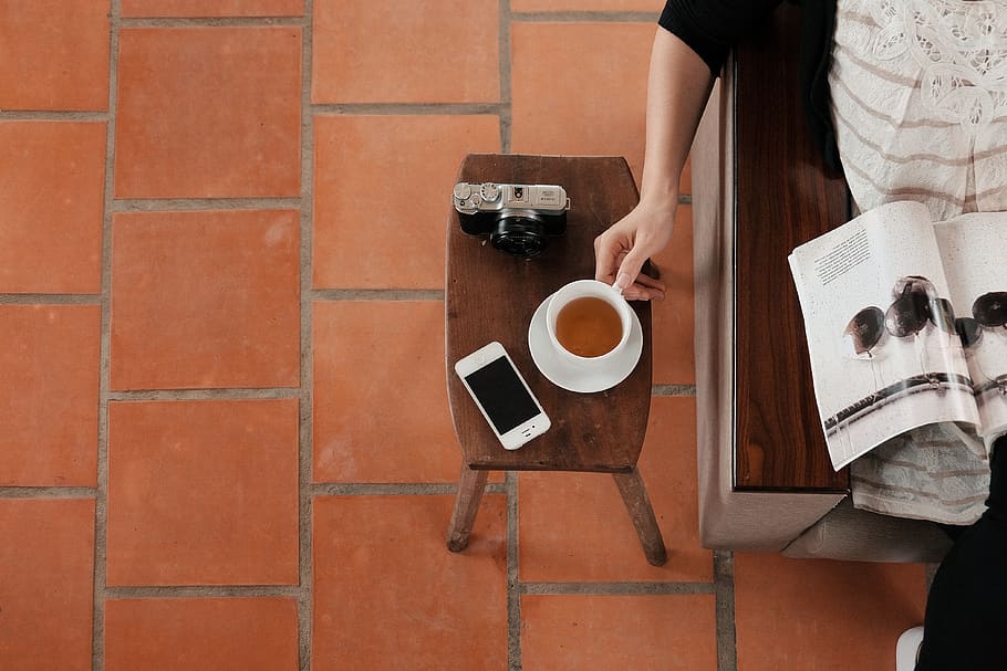 kaffe, pause, hvile, krus, kop, cafe, læsning, magasin, kvinde, drikke, bord, hvilende, sidder, nyder, kamera, telefon, udstyr, kaffe - drikke, kaffekop, mad og drikke, forfriskning, en person, Kvinder, bedrift, voksen, ung voksen, varm drikke, menneskelig kropsdel, hånd, midsection, unge kvinder, te kop, bakke, mursten, porcelæn, kaffekande, 4K