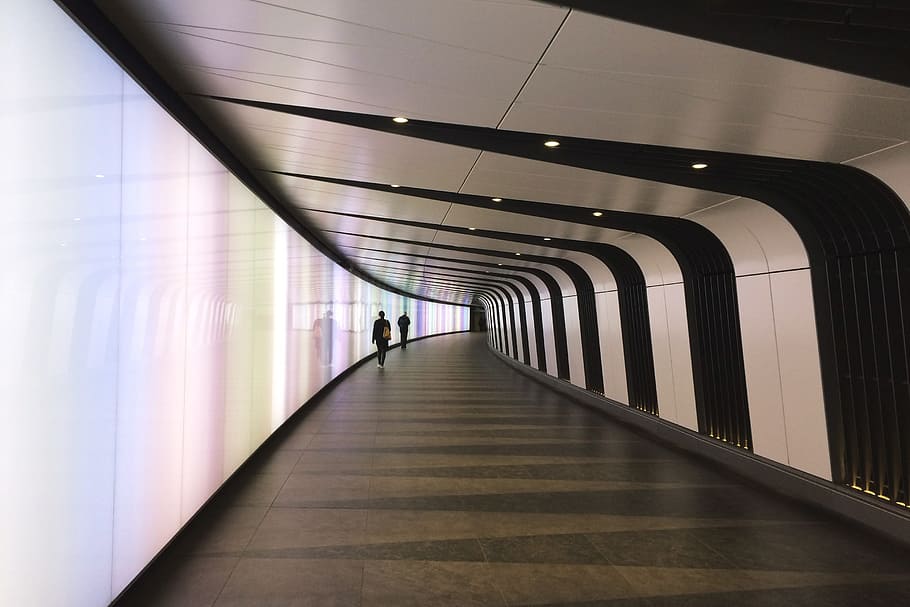 futuristic tunnel, architecture, the way forward, direction, illuminated, indoors, transportation, walking, built structure, ceiling, arcade, corridor, diminishing perspective, flooring, lighting equipment, incidental people, real people, public transportation, subway, motion, footpath, tiled floor, 2K