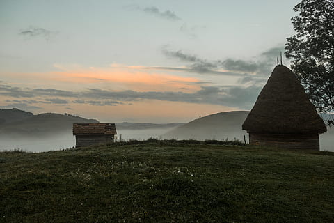 marró, refugi, arbre, camp de gespa, arquitectura, núvols, alba, la llum del dia, primerenc, explorar, boira, herba, turons, casa, paisatge, al matí, muntanya, naturalesa, oceà, a l'aire lliure, escènic, cel, sortida del sol, posta de sol, viatjar, arbres, estructura construïda, planta, núvol - cel, escenics - natura, bellesa a la natura, cap gent, exterior de l'edifici, terra, camp, edifici, tranquil·litat, escena tranquil·la, medi ambient, 5K, CC0, domini públic, lliure de regalies
