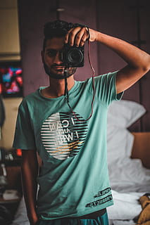 person, holding, black, camera, fine-looking, guy, handsome, male, man, taking photo, wear, waist up, front view, indoors, one person, photography themes, casual clothing, technology, young adult, standing, young men, real people, furniture, camera - photographic equipment, music, leisure activity, photographing, focus on foreground, lifestyles, photographer, 4K, CC0, public domain, royalty free