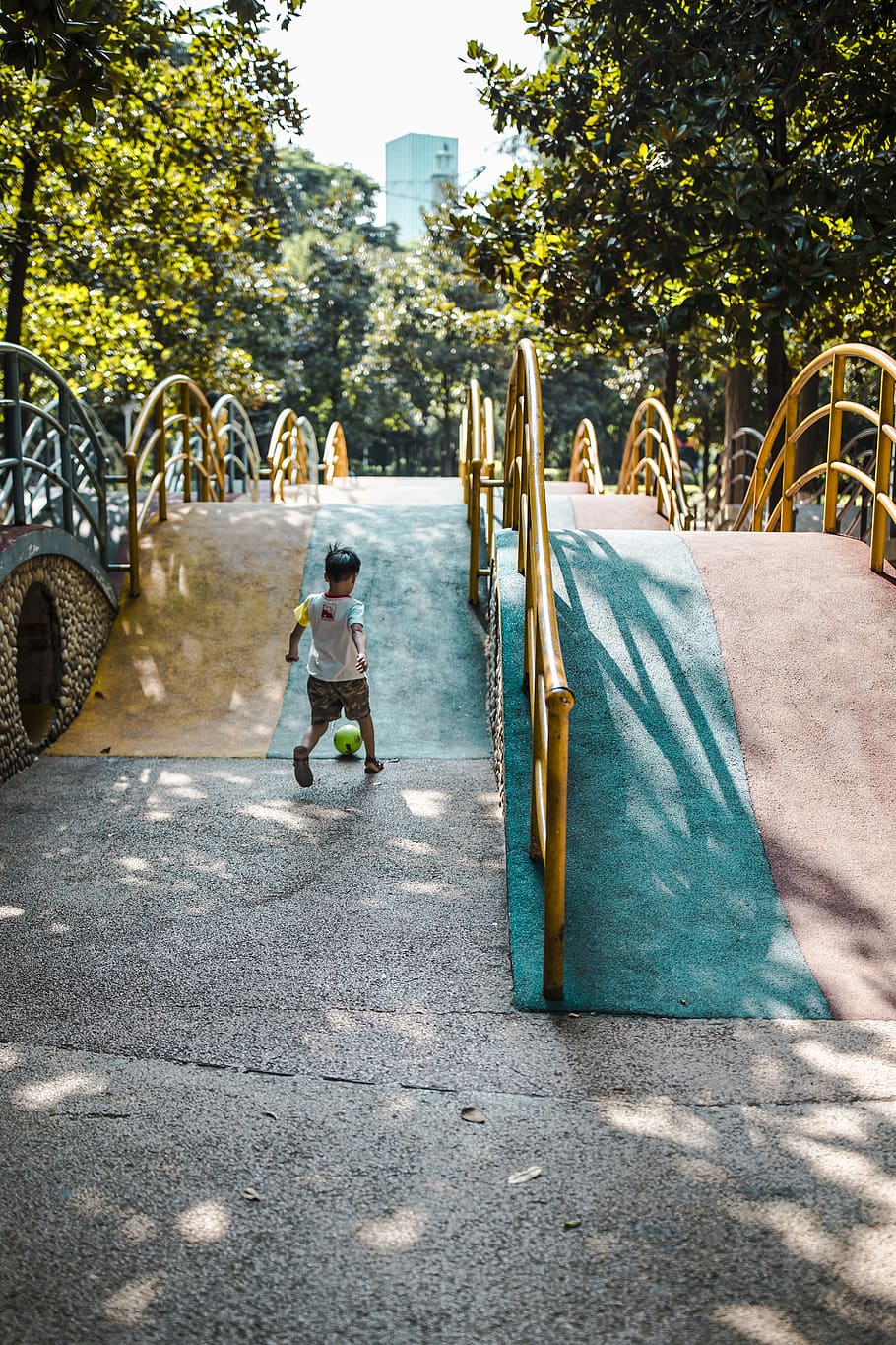noi, jugant, sòl, acció, la llum del dia, futbol, felicitat, oci, moviment, a l'aire lliure, parc, jugar, parc infantil, recreació, fill, estiu, fusta, persones reals, nen, arbre, una persona, infància, dia, planta, naturalesa, longitud completa, ciutat, transport, nois, dones, arquitectura, estils de vida, femelles, roba casual, llum solar, homes, innocència, 4K