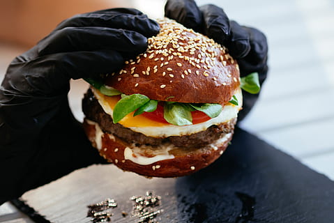 person, der holder burger, bøf, brød, bolle, burger, cheeseburger, tæt på, lækker, aftensmad, fastfood, mad, handsker, hamburger, hænder, salat, frokost, måltid, kød, sandwich, sesam, snack, velsmagende, tomat, grøntsag, mad og drikke, en person, klar til at spise, usund spisning, friskhed, fokus på forgrunden, dag, overbærenhed, frø, tag mad ud, fristelse, 5K, CC0, offentligt domæne, royaltyfrie