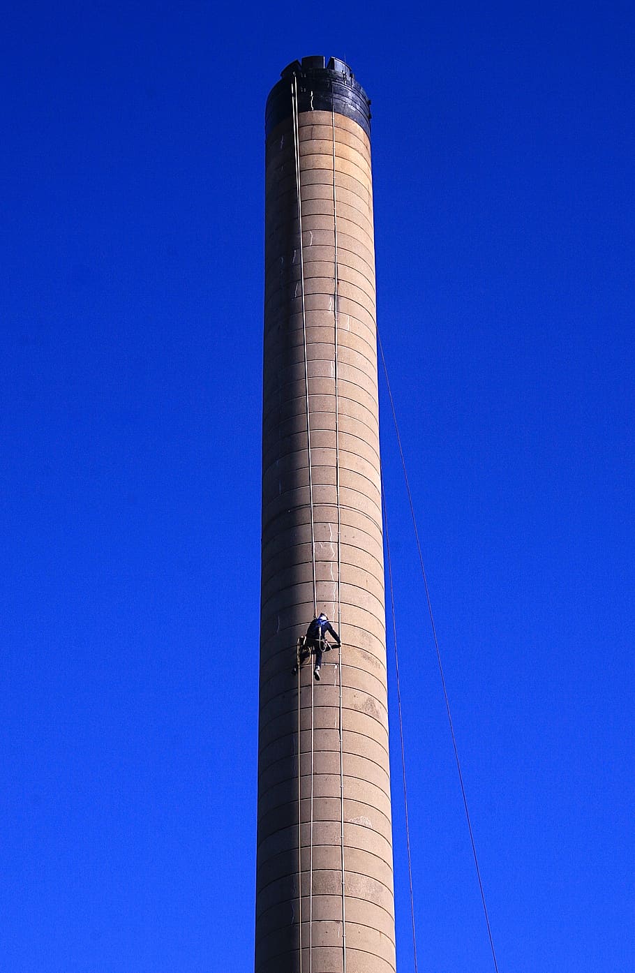 torre marró, maó, arquitectura, edifici, torre, monument, columna, pilar, planta, vegetació, arbust, obelisc, transport, avió, vehicle, avió de línia, avions, fletxa, campanar, torre de control, a l'aire lliure, cel, blau, cel clar, vista d’angle baix, estructura construïda, còpia espai, exterior de l'edifici, dia, naturalesa, indústria, fàbrica, llum solar, alta - alta, pila de fums, cap gent, 2K