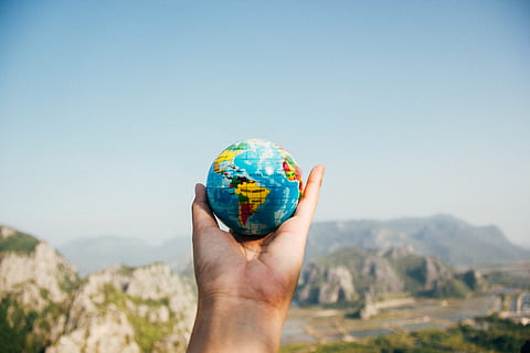 globe, global, map, round, colorful, outdoor, hand, palm, view, sky, mountain, highland, landscape, nature, human hand, human body part, environment, holding, one person, globe - man made object, day, clear sky, blue, copy space, body part, outdoors, mountain range, sunny, focus on foreground, human limb, 5K